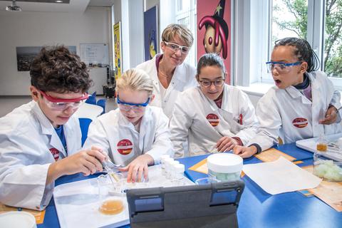 Faszinierend für Groß und Klein: Melanie Maas-Brunner, Vorstandsmitglied der BASF SE, schaut den Jungforschern im Kids Lab beim Experimentieren über die Schulter. Foto: BASF