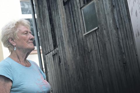 Hildegard Berger vor der wiederaufgebauten Holzgarage, in der die grauen Busse Euthanasieopfer in der Tötungsanstalt Hadamar ablieferten. Foto: Frank Schmidt-Wyk