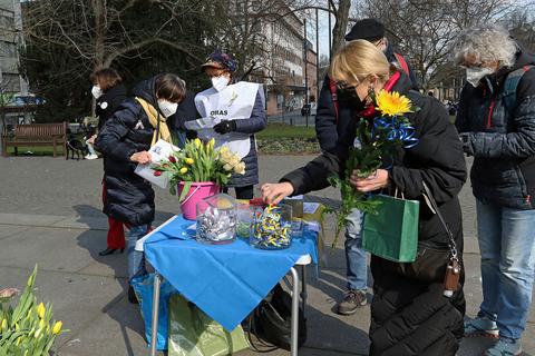 Solidarität und Gedenken mit Blumen und Schleifen: An einem kleinen Stand der „Omas gegen Rechts“ auf dem Lutherplatz werden Tulpen und Rosen sowie blau-gelbe Schleifchen gegen Spenden angeboten.