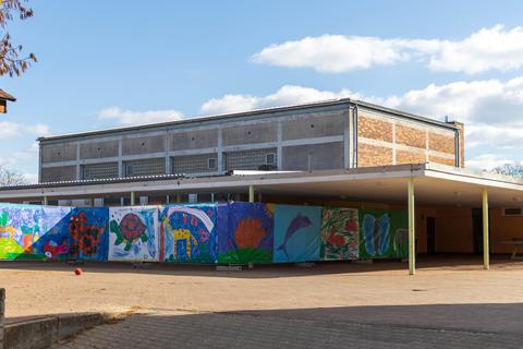 Ein verzierter Bauzaun trennt die Turnhalle vom Rest des Schulhofs der Wiesengrundschule Worms-Heppenheim.