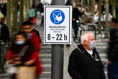 Ein Mann steht mit Maske neben einem Hinweisschild ·Maskenpflicht· auf der Einkaufsstraße Zeil in Frankfurt. Archivfoto: dpa
