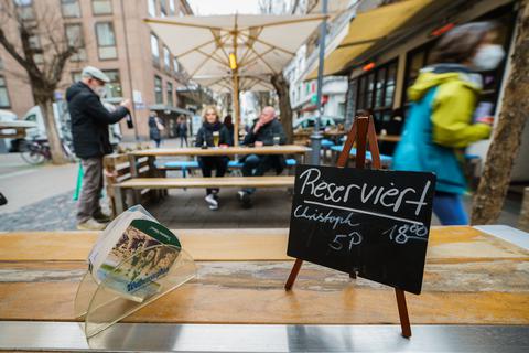 Das Schild „Reserviert, Christoph, 5 Personen, 18 Uhr“ steht in der „Zeitungsente“ in Mainz auf einem Tisch. Im März war die Öffnung der Außengastronomie kurzzeitig erlaubt, weil der Inzidenzwert unter 100 lag. Foto: dpa
