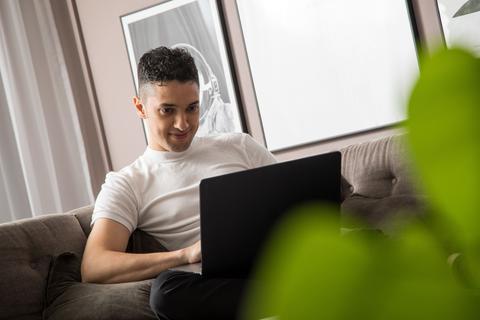 Junger Mensch mit Laptop
