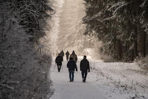 Wanderer laufen durch die verschneite Natur.  Foto: dpa - Swen Pförtner