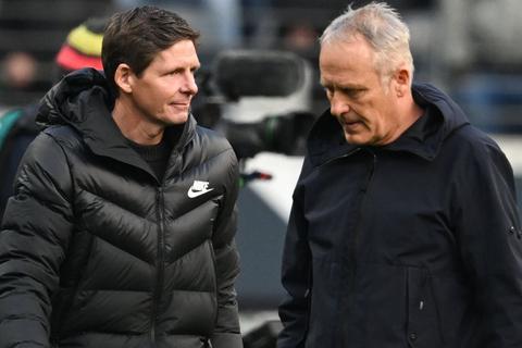 Frankfurts Cheftrainer Oliver Glasner (l) und Freiburgs Trainer Christian Streich gehen nach dem Spiel über den Platz.   Foto: Arne Dedert/dpa
