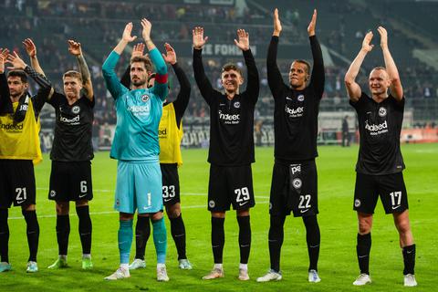 Frankfurts Lucas Alario (l-r), Kristijan Jakic, Torhüter Kevin Trapp, Luca Pellegrini, Jesper Lindström, Timothy Chandler und Sebastian Rode jubeln nach der Partie mit den Fans.