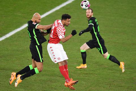 Der Mainzer Karim Onisiwo (M) spielt gegen Wolfsburgs John Anthony Brooks (l) und Maximilian Arnold.  Foto: Torsten Silz/dpa