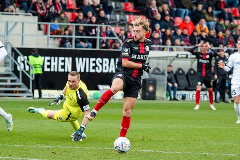 Der erste Streich: Ingolstadts Keeper Marius Funk hat gerade über den Ball ein Luftloch getreten und Benedict Hollerbach kann die Kugel im nächsten Moment ins leere Tor einschieben.