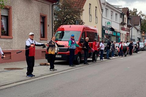 Rund 100 Mitglieder des Mombacher TV bilden eine Menschenkette zwischen den beiden MTV-Hallen. Damit wollen sie auf die schwierige finanzielle Situation des Vereins hinweisen, die durch die Energiekrise zusätzlich verschärft wird. Foto: Mombacher TV 
