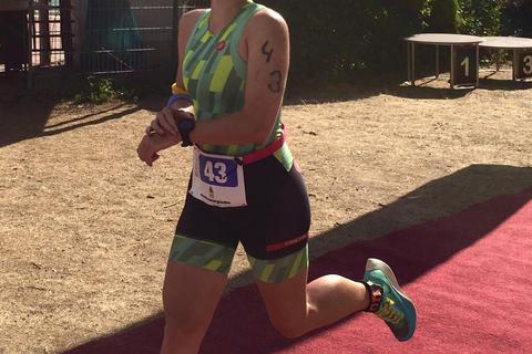 Laetitia Bury, die schnellste Frau beim Triathlon Festival Rheinhessen, stoppt beim Zieleinlauf ihre Uhr. Foto: Poseidon Worms